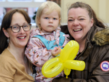 Two women with a child holding a balloon