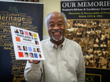 Man holding a book called 'England is my home'